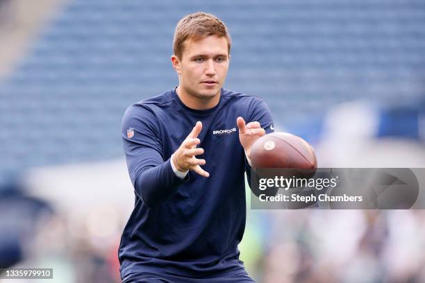 Quarterback Drew Lock of the Denver Broncos warms up before an NFL preseason game against the Seattle Seahawks at Lumen Field on August 21, 2021 in...