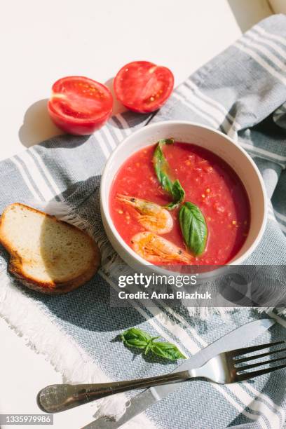 spanish traditional cold tomato soup gazpacho with shrimps on white table in bright sunlight - gazpacho stock pictures, royalty-free photos & images