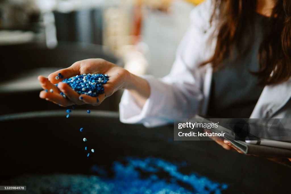 Technikerin bei der Inspektion von Pellets aus biologisch abbaubaren Materialien