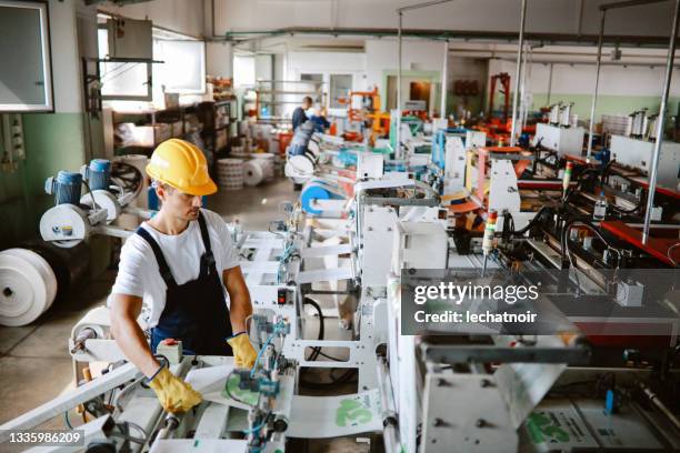 man working on the industrial machinery for recycling plastic - electrical equipment stock pictures, royalty-free photos & images