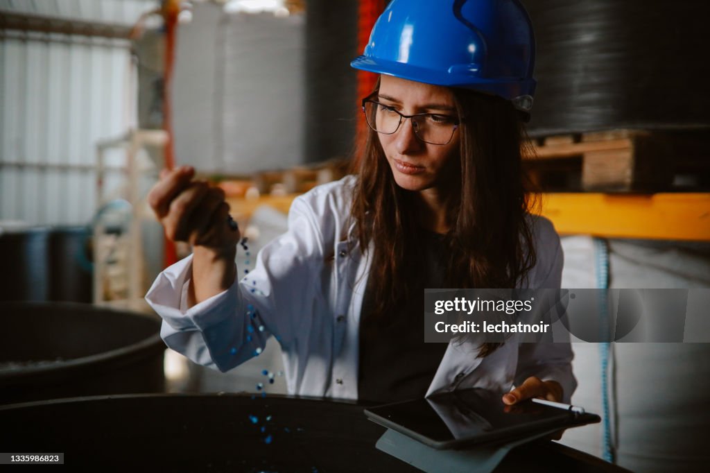 Porträt einer Technikerin, die Pellets aus biologisch abbaubaren Materialien inspiziert