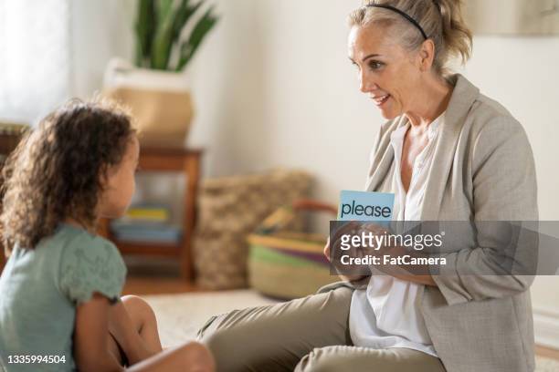 female speech therapist using a flash card with a child patient - flash card stock pictures, royalty-free photos & images