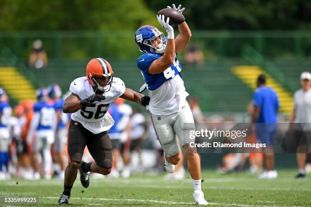 Tight end Cole Hikutini of the New York Giants catches a pass against outside linebacker Malcolm Smith of the Cleveland Browns during a joint...