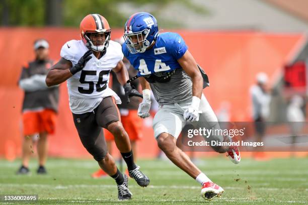 Tight end Rysen John of the New York Giants runs a drill against outside linebacker Malcolm Smith of the Cleveland Browns during a joint practice on...