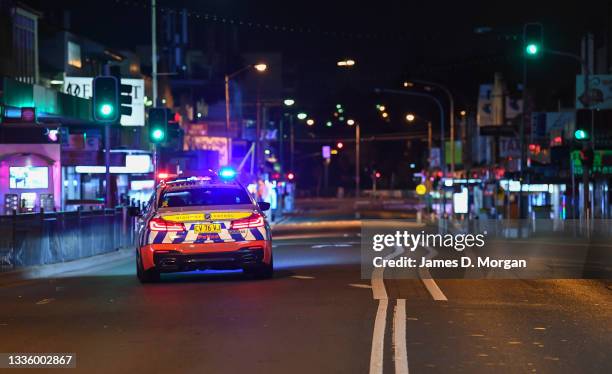 Police vehicle patrols the main street in the suburb of Merrylands as the 9pm curfew commences on August 23, 2021 in Sydney, Australia. Further...