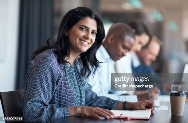 shot of a group of businesspeople having a meeting in the boardroom of a modern office - 50s woman writing at table stock pictures, royalty-free photos & images