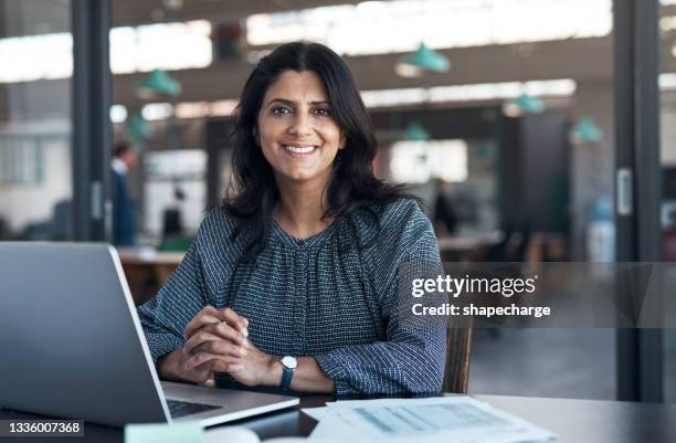 aufnahme einer reifen geschäftsfrau mit einem laptop in einem modernen büro - indischer abstammung stock-fotos und bilder