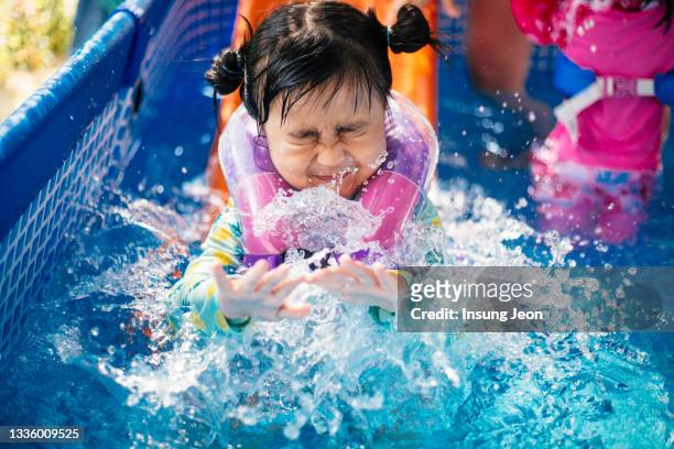 little girl having fun in backyard swimming pool - like a child in a sweet shop stock pictures, royalty-free photos & images