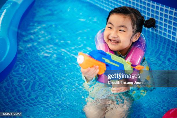 little girl having fun in backyard swimming pool - like a child in a sweet shop stock pictures, royalty-free photos & images