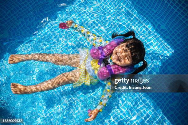 little girl having fun in backyard swimming pool - like a child in a sweet shop stock pictures, royalty-free photos & images