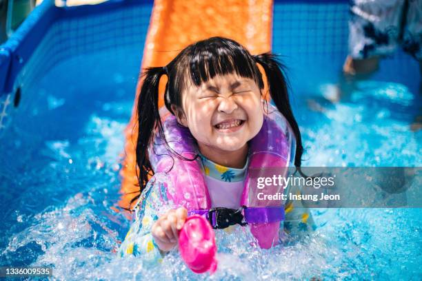 little girl having fun in backyard swimming pool - like a child in a sweet shop stock pictures, royalty-free photos & images