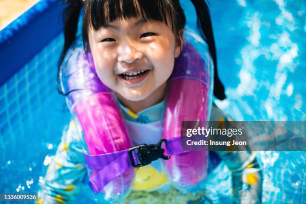 little girl having fun in backyard swimming pool - like a child in a sweet shop stock pictures, royalty-free photos & images