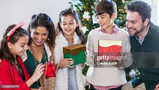 children opening christmas gifts, with parents - christmas tree close up stock pictures, royalty-free photos & images