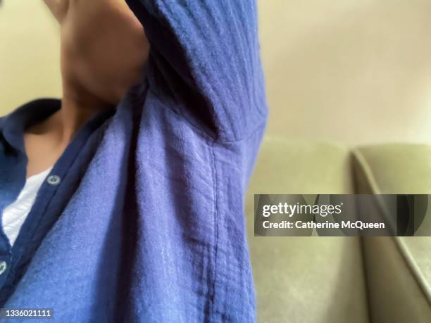 african-american woman checks under her arm for scent - celebrity armpits stockfoto's en -beelden