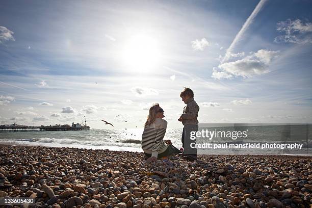 mother and son on brighton beach - brighton beach foto e immagini stock