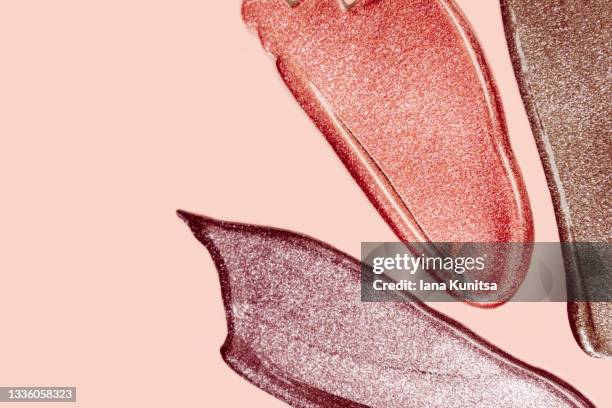 set of brown lipstick, eyeshadows, nail polish smears on beige background. lip gloss samples are smudged. beauty cosmetic. makeup and skin care products. closeup. - lipstick background stock pictures, royalty-free photos & images