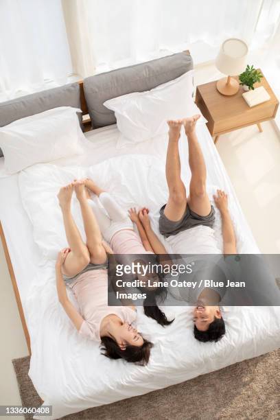happy young family having fun on bed - barefoot feet up lying down girl stockfoto's en -beelden