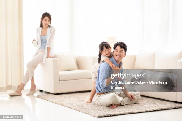 happy young family relaxing in living room - small child sitting on floor stock-fotos und bilder