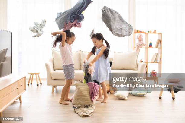 cute chinese children playing in living room - rough housing stockfoto's en -beelden