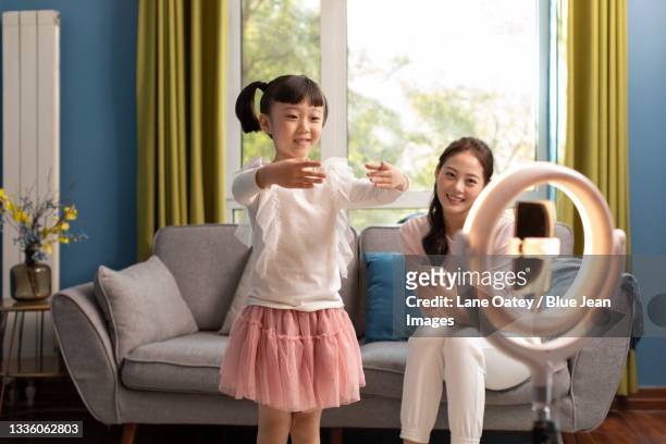 little chinese girl doing live webcast at home - girls television show stock-fotos und bilder