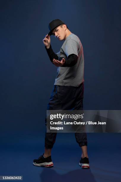 studio shot of fashionable young chinese man dancing - beckoning stock pictures, royalty-free photos & images