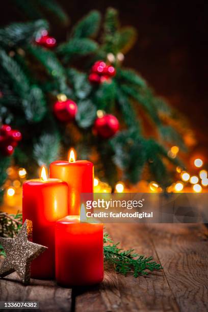 christmas candles on rustic table - christmas candles stockfoto's en -beelden