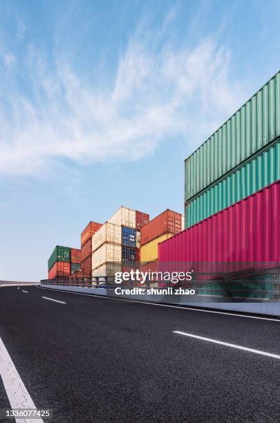 the elevated road next to the container yard - shipping containers green red stock-fotos und bilder