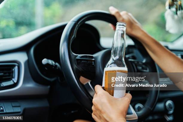 young drunk woman drinking a beer while driving her car. - dui stock-fotos und bilder