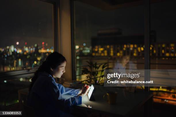 femme d’affaires concentrée travaillant tard avec sa tablette - distrait photos et images de collection