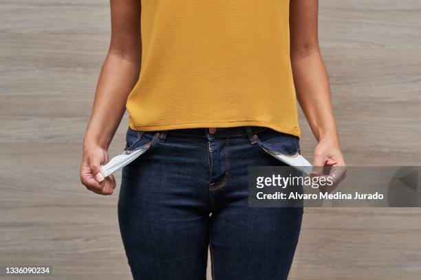 unrecognizable young women showing her empty pockets without money. - pocket ストックフォトと画像