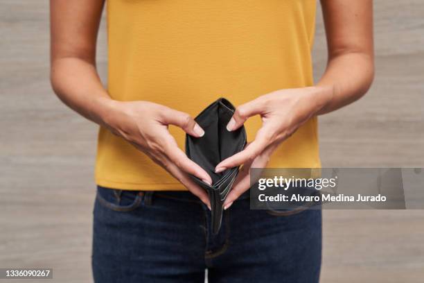 unrecognizable young women showing her wallet empty of money. - wallet money stock pictures, royalty-free photos & images