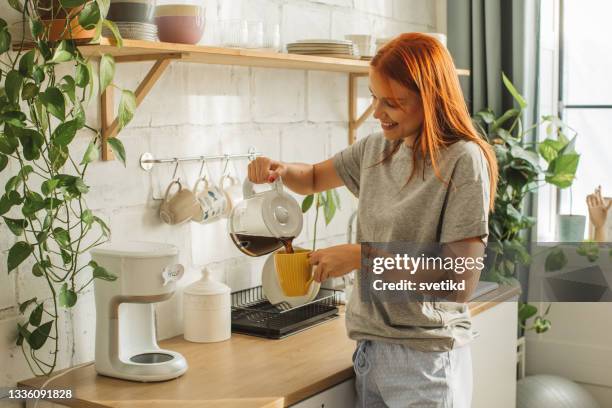 college student at dorm room - woman drinking phone kitchen stockfoto's en -beelden