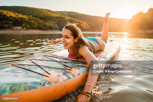 woman swims on a paddle board - paddle board men imagens e fotografias de stock