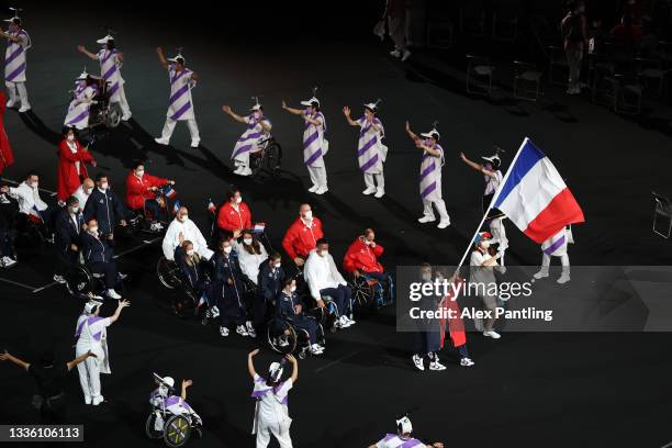 Flag bearers Sandrine Martinet and Stephane Houdet of Team France lead their delegation in the parade of athletes during the opening ceremony of the...