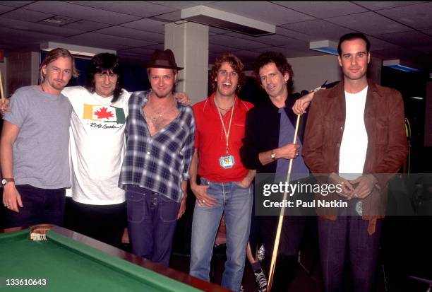 Backstage at the Rolling Stones' 'Voodoo Lounge' tour, British musicians Ron Wood and Keith Richards of the Rolling Stones pose with member of the...