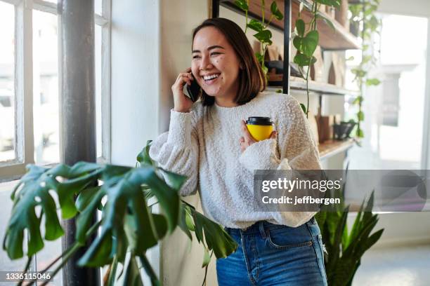 shot of a young woman talking on the phone at home - on phone stock pictures, royalty-free photos & images