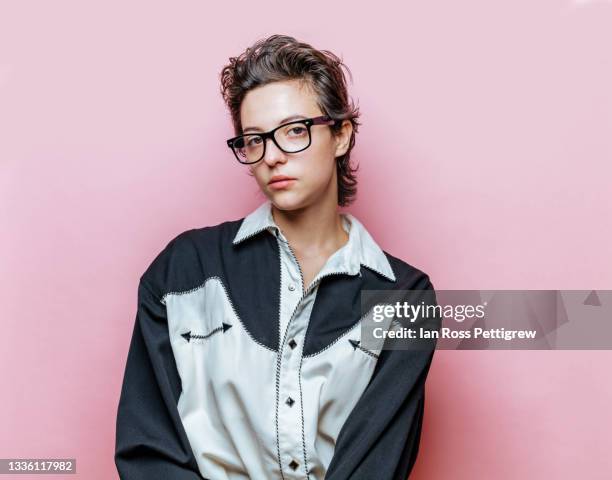 androgynous young woman, cowboy shirt on pink - androgynous stock-fotos und bilder