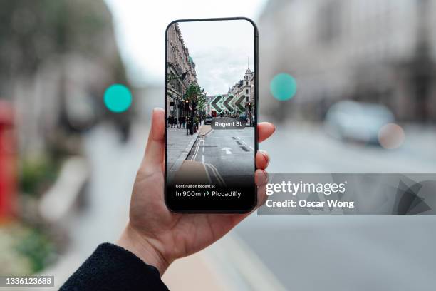 finding direction with augmented reality on smartphone on street - erweiterte realität stock-fotos und bilder