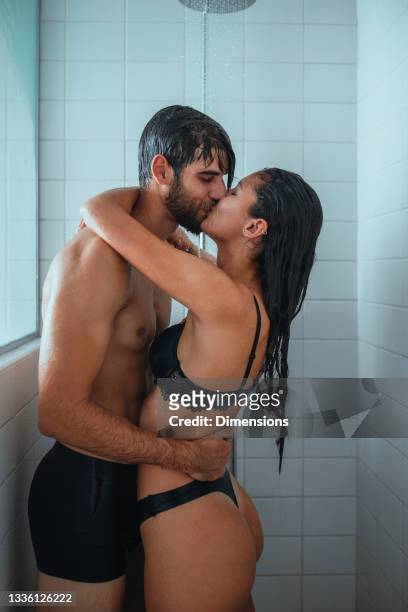junges paar küsst sich unter der dusche - couple and kiss and bathroom stock-fotos und bilder