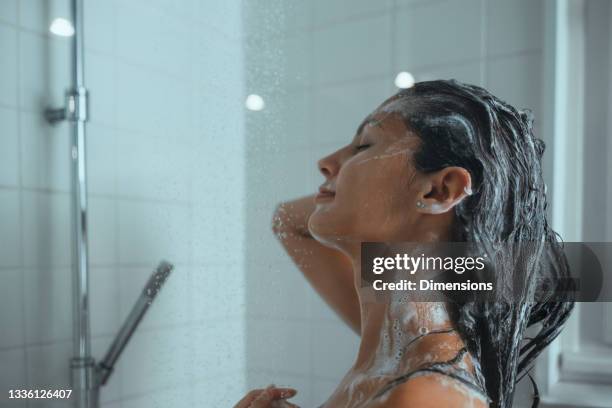 female taking a shower and washing her hair at home - woman shampoo stock pictures, royalty-free photos & images