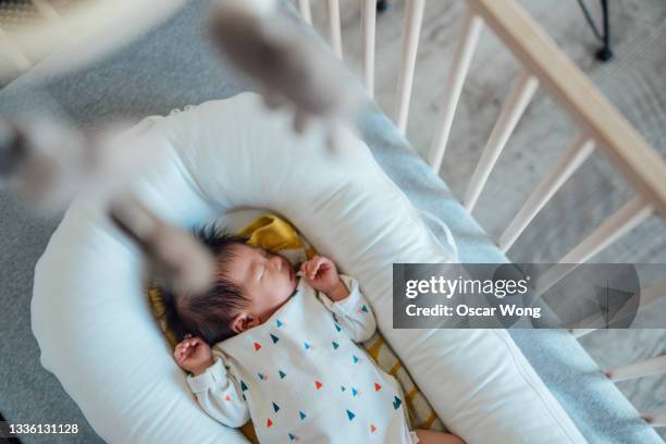 cute asian baby sleeping in crib - wieg stockfoto's en -beelden