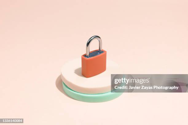 orange padlock on pastel background - candado fotografías e imágenes de stock