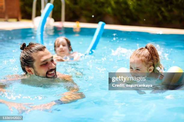 Kid In Pool With Parent Family With Two Children Splashing Water In Resort Swimming Pool Photos ...