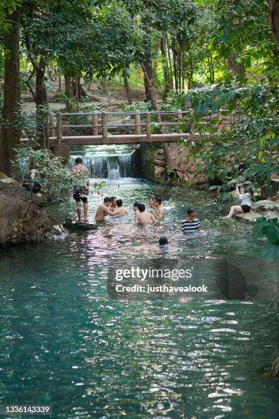 capture of group of bathing thai people at and in  river of ban tha chang spring in khao yai - river bathing imagens e fotografias de stock