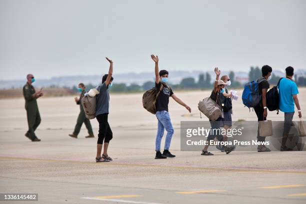 Group of young Afghans wave, before boarding a U.S. Plane to be transferred to Germany, at the Torrejon de Ardoz air base, August 24 in Madrid,...