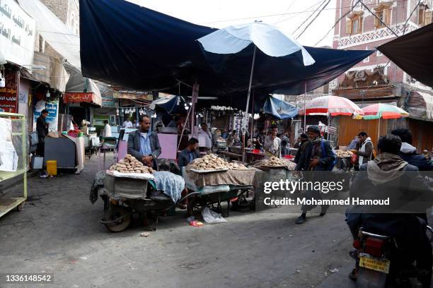 Yemenis walk at a market while shopping for food on August 24, 2021. In Monday's UN Security Council's session, Yemen's former Special Envoy Martin...