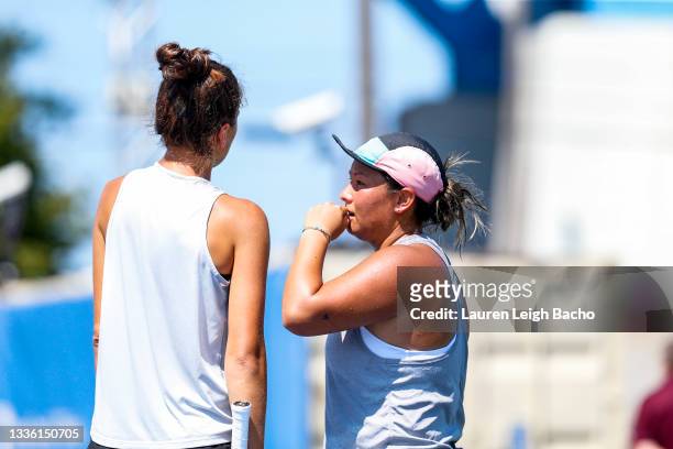 Tara Moore of Great Britain whispers to Emina Bektas of USA during their doubles match against Ulrikke Eikeri of Norway and Catherine Harrison of USA...
