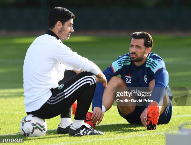 Mikel Arteta the Manager of Arsenal chats to Pablo Mari during the Arsenal 1st team training session at Arsenal Training Centre on August 24, 2021 in...