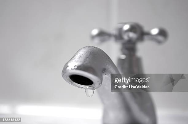 dripping silver tap water close up - tap stockfoto's en -beelden