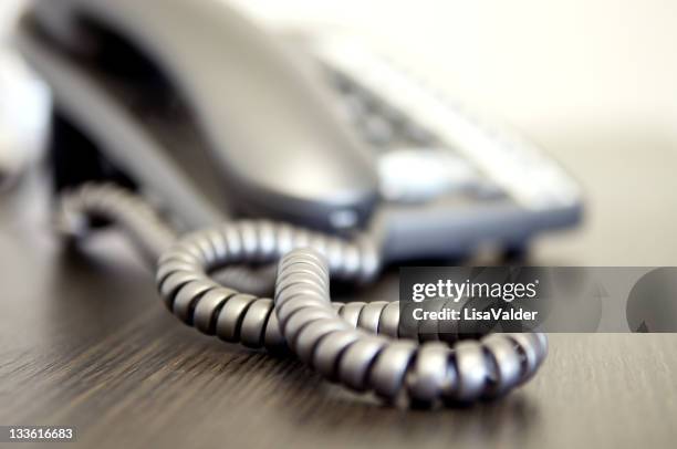 a close-up of a wired telephone on a wood table - phone number stock pictures, royalty-free photos & images